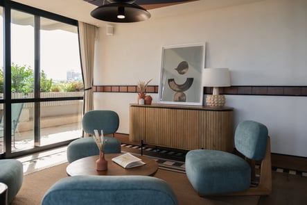 Bright modern interior of an Ando Living residence in Lisbon, featuring contemporary design, pastel-toned furniture, and access to a balcony with an urban view.