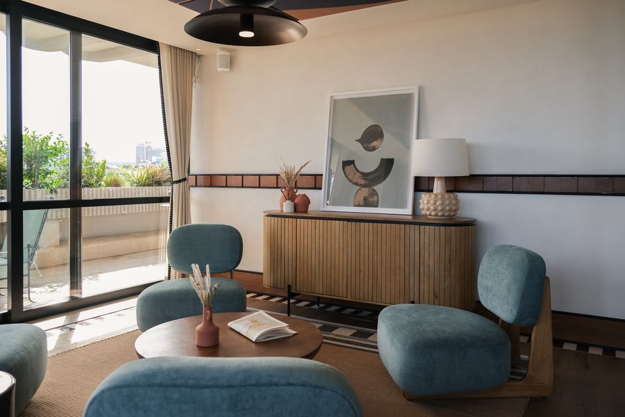 Bright modern interior of an Ando Living residence in Lisbon, featuring contemporary design, pastel-toned furniture, and access to a balcony with an urban view.