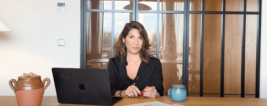 Businesswoman working in a modern office with a laptop, decorative pottery, and natural light, representing a professional and inspiring workspace in Portugal.