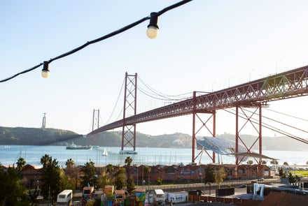 Panoramic view of the 25 de Abril Bridge and Cristo Rei statue in Lisbon, Portugal, overlooking the Tagus River — iconic landmarks connecting Lisbon and Almada.