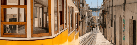 Yellow tram on the historic streets of Lisbon, symbolizing the charm and authenticity of Portugal’s capital — a prime destination for tourism and real estate investment.