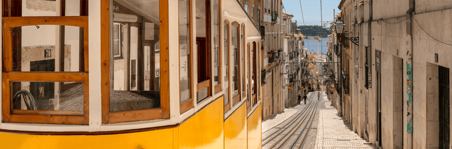 Yellow tram on the historic streets of Lisbon, symbolizing the charm and authenticity of Portugal’s capital — a prime destination for tourism and real estate investment.