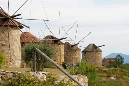 Traditional stone windmills in the rural landscape of Portugal, symbolizing Portuguese heritage and traditional architecture.
