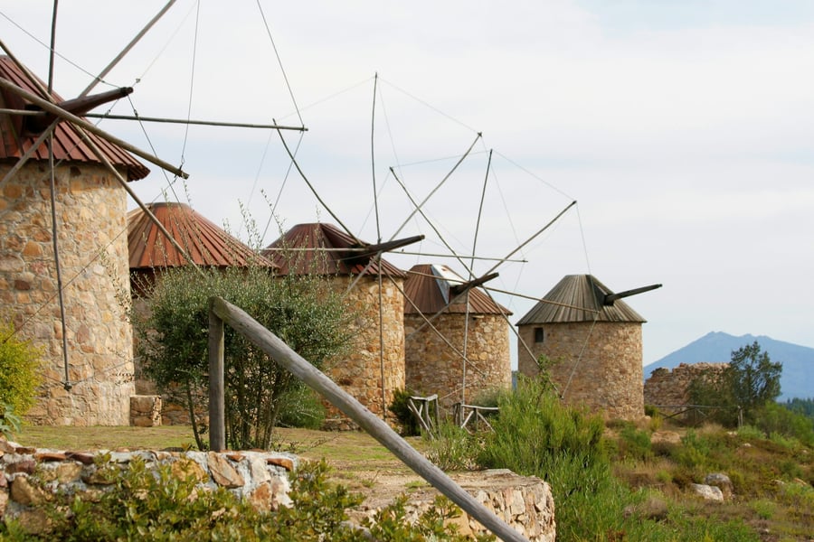 Traditional stone windmills in the rural landscape of Portugal, symbolizing Portuguese heritage and traditional architecture.